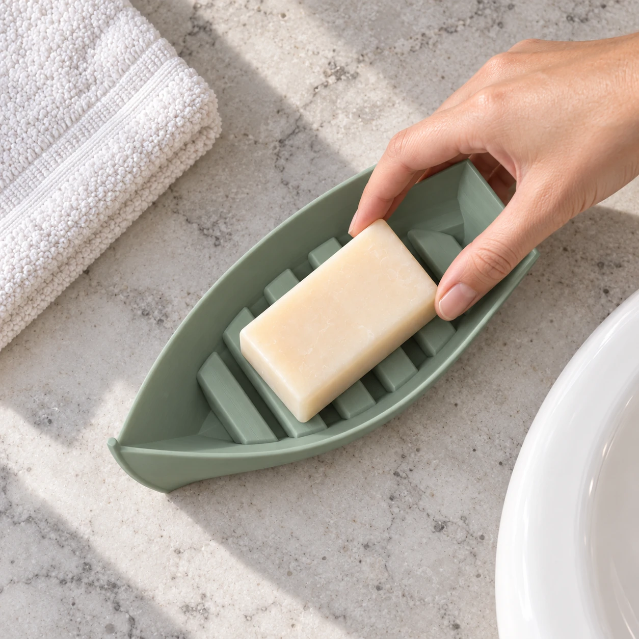 Illustrative overhead sink-side view of soap being taken from the sage green boat dish